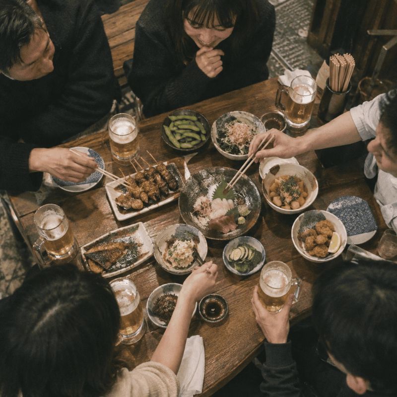 居酒屋で料理を囲むお客さま